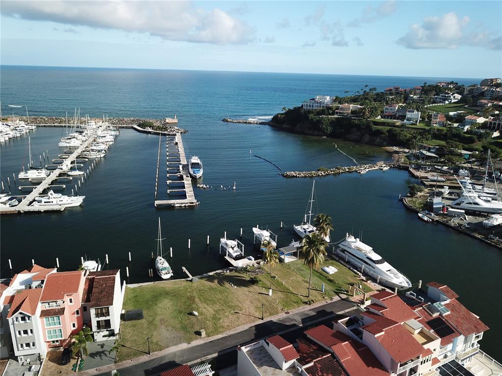 An aerial view shows a marina with docked boats and surrounding residential buildings — SAN MIGUEL 48, HUMACAO, PR