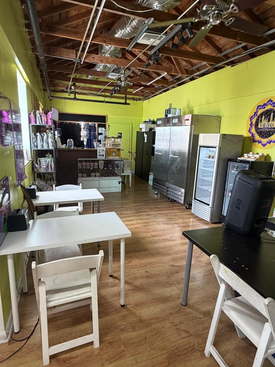 A commercial space features lime green walls, exposed wooden ceiling rafters, and white tables — 139 NE 1st Ave, Hallandale Beach FL 33009, HALLANDALE BEACH, FL