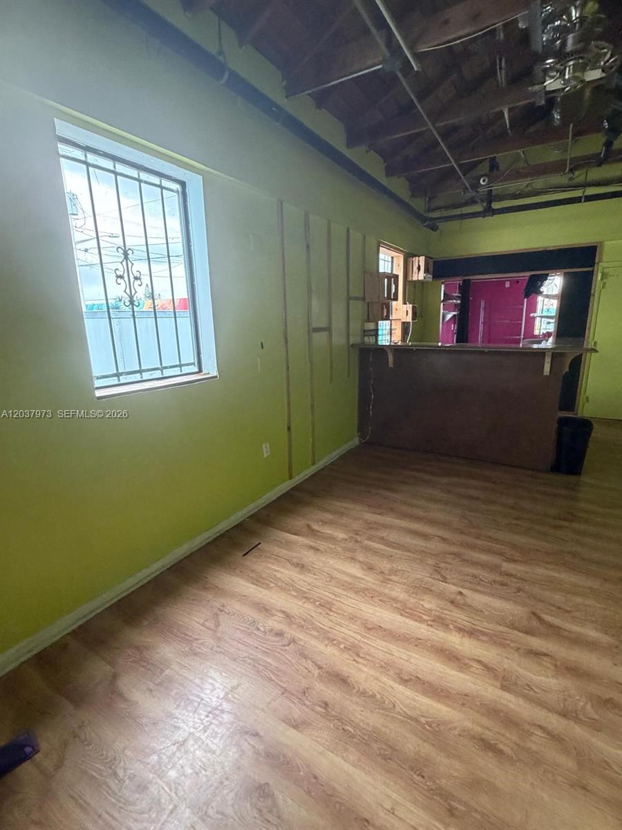 An interior room features light green walls, wood-look flooring, an exposed ceiling, and a bar — 139 NE 1st Ave, Hallandale Beach FL 33009, HALLANDALE BEACH, FL