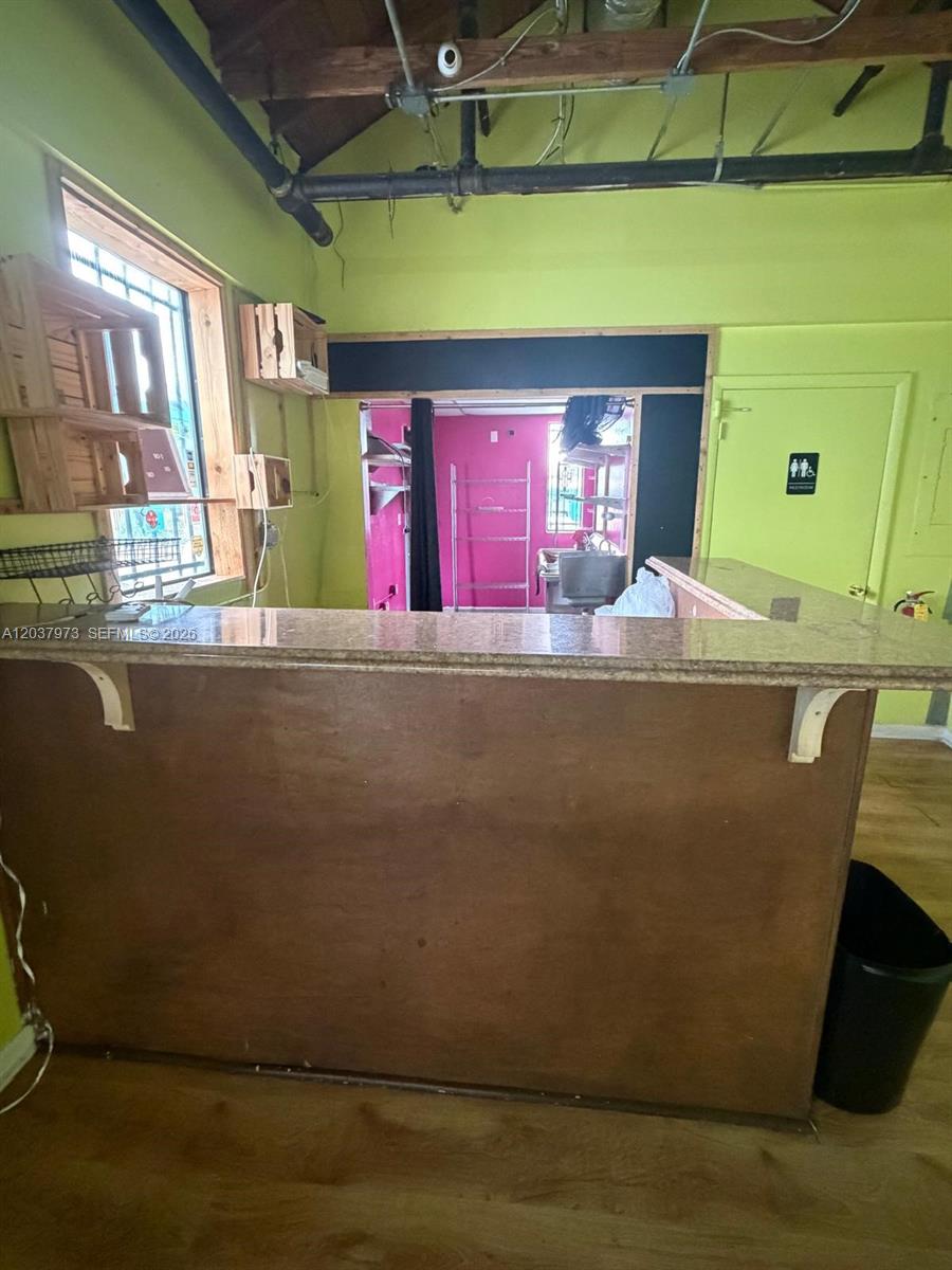 A room features a wooden bar counter, lime green walls, and an open doorway — 139 NE 1st Ave, Hallandale Beach FL 33009, HALLANDALE BEACH, FL