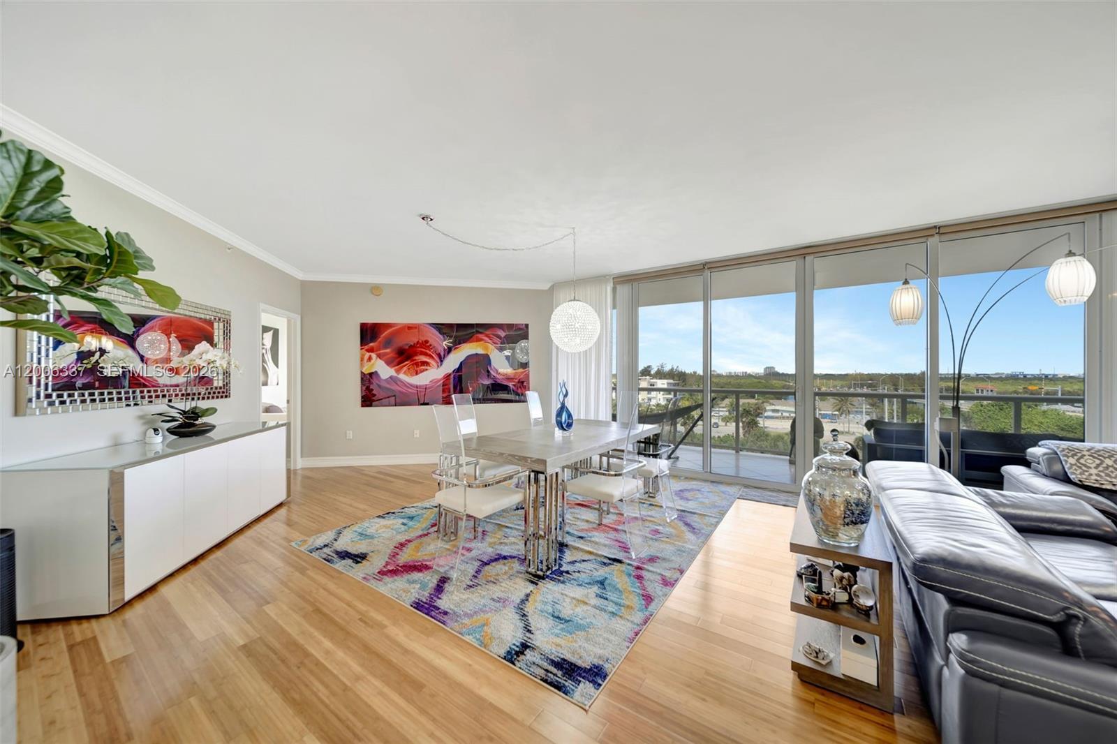 A dining area with a patterned rug and glass table sits beside a living room — 6051 N Ocean Dr # 603, Hollywood FL 33019, HOLLYWOOD, FL