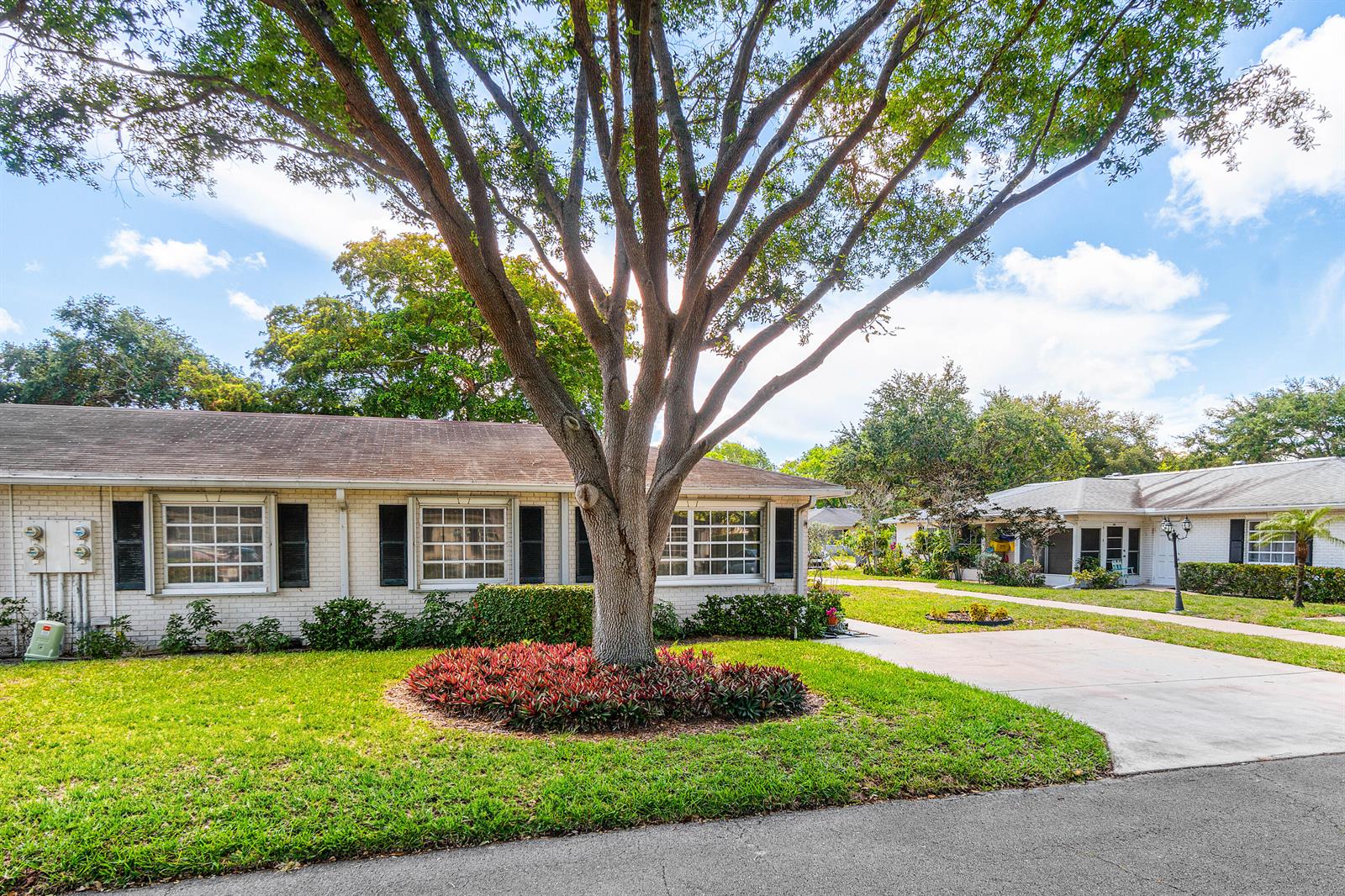 A single-story brick building features a large tree in the front yard with red landscaping — 10141 S 41st Dr Drive # 193, Boynton Beach FL 33436, BOYNTON BEACH, FL