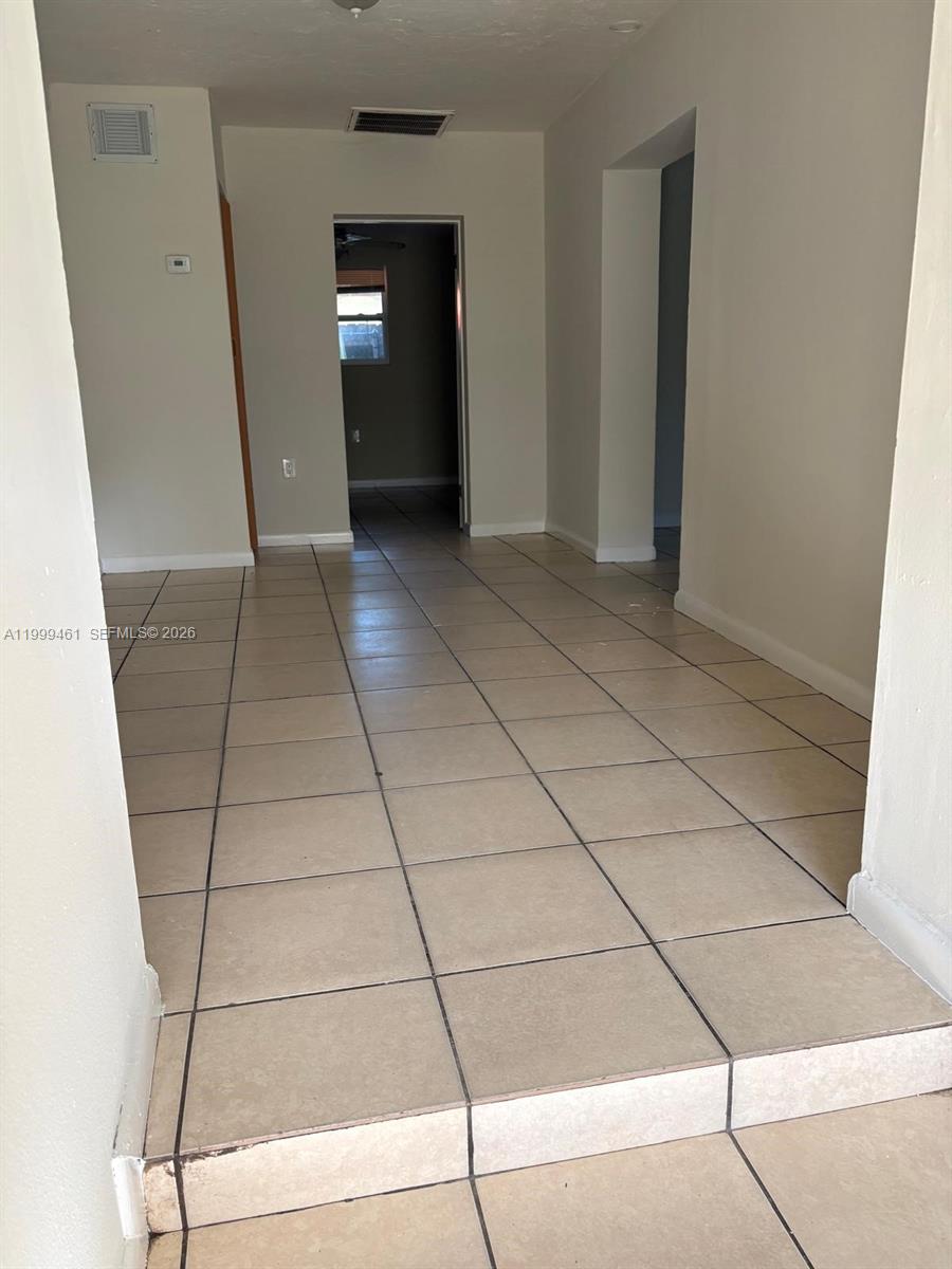 A tiled hallway leads to a doorway with a view into another room — 1384 NW 27th St # 1382, Miami FL 33142, MIAMI, FL