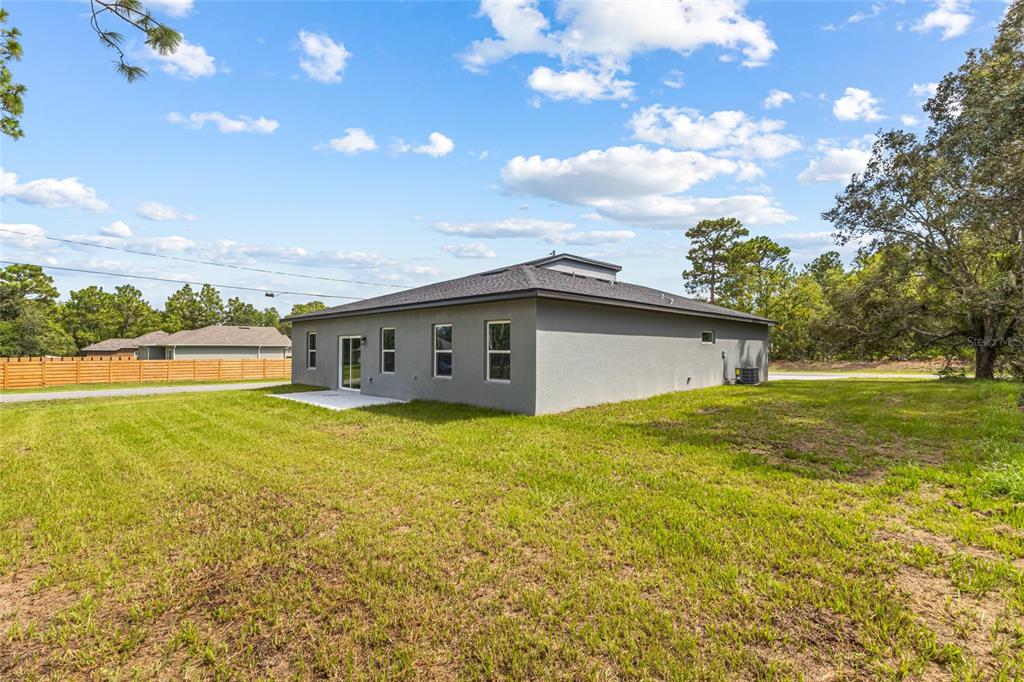 A gray single-story house with a blue garage door and a concrete driveway — 1071 W HAMPSHIRE BOULEVARD, DUNNELLON, FL