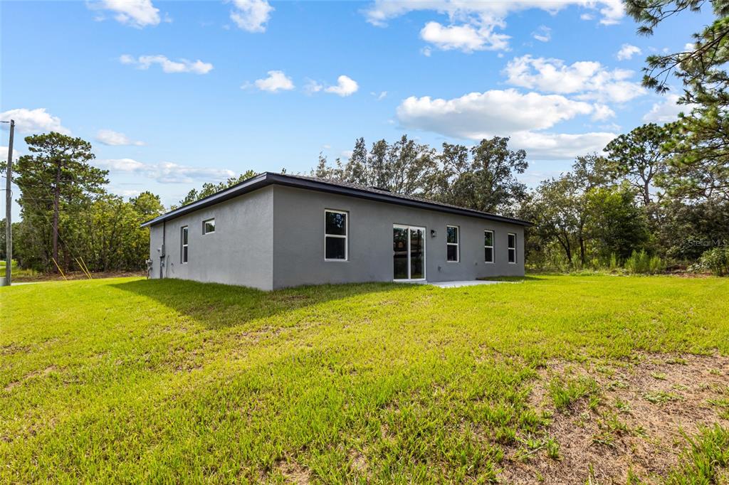 An aerial view shows a single-story house with a gray roof and a concrete driveway — 1071 W HAMPSHIRE BOULEVARD, DUNNELLON, FL