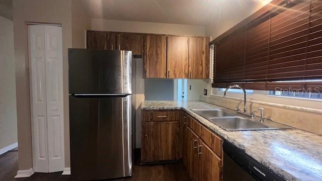 A kitchen features wood cabinets, stainless steel appliances, and a granite countertop with a sink — 507 HUNTER CIRCLE, KISSIMMEE, FL