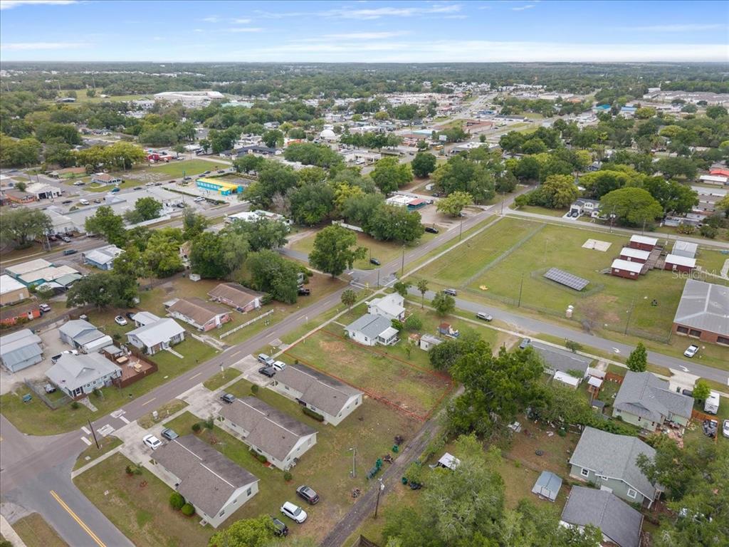 An aerial view shows a residential neighborhood with a vacant lot outlined in red — 5540 8TH STREET, ZEPHYRHILLS, FL