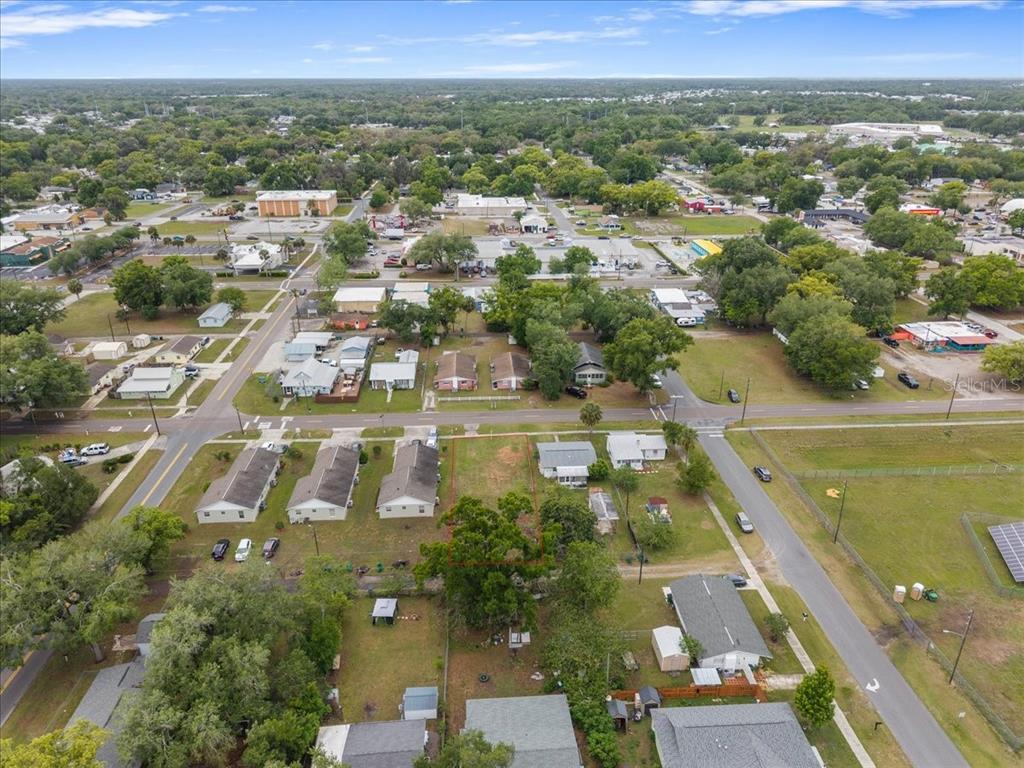 An aerial view shows a vacant rectangular lot outlined in red within a residential neighborhood — 5540 8TH STREET, ZEPHYRHILLS, FL