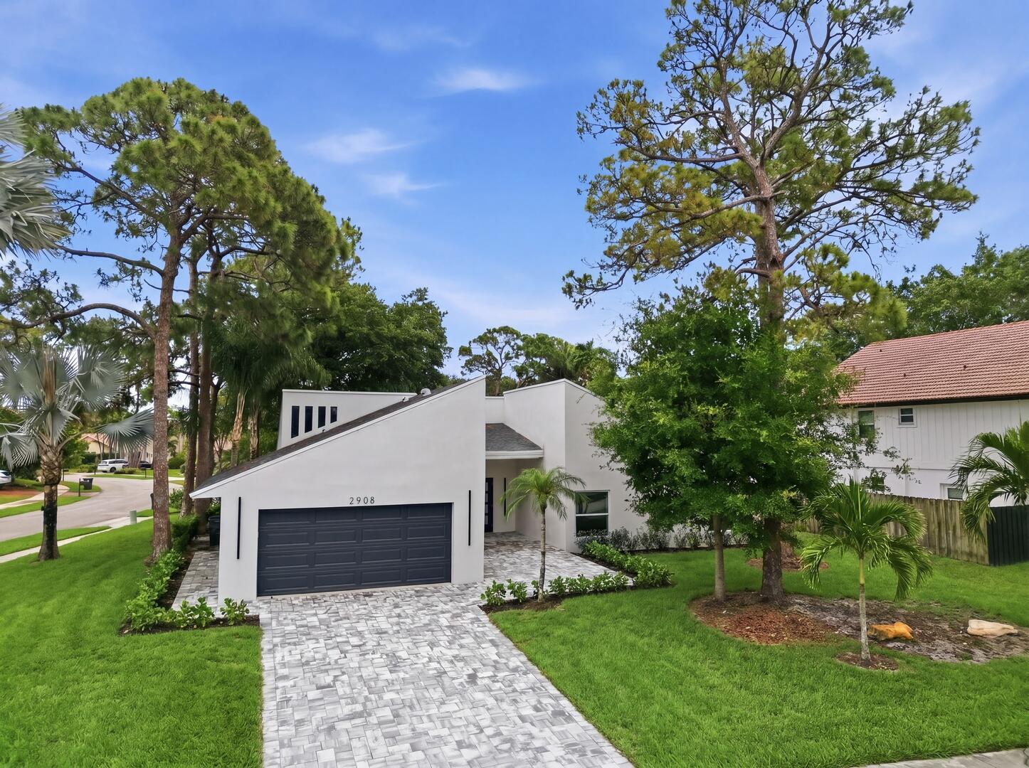 A modern white house with a dark garage door and a paved driveway — 2908 NW 24th Way, Boca Raton FL 33431, BOCA RATON, FL