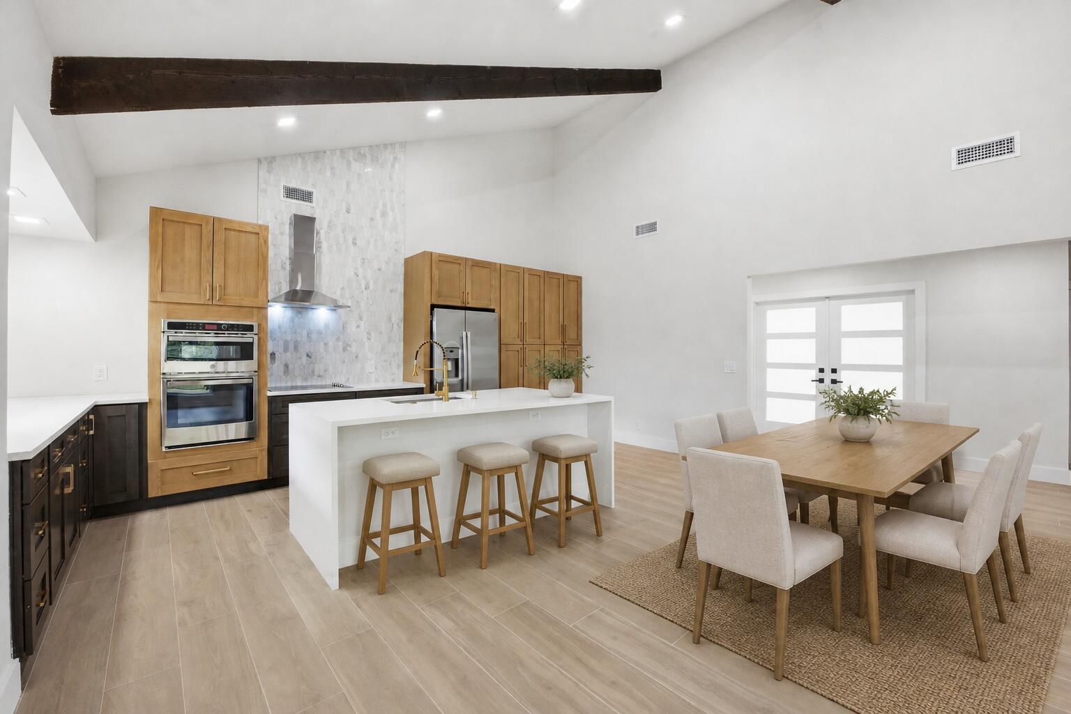 A modern kitchen and dining area with light wood cabinets, a white island, and vaulted ceilings — 2908 NW 24th Way, Boca Raton FL 33431, BOCA RATON, FL