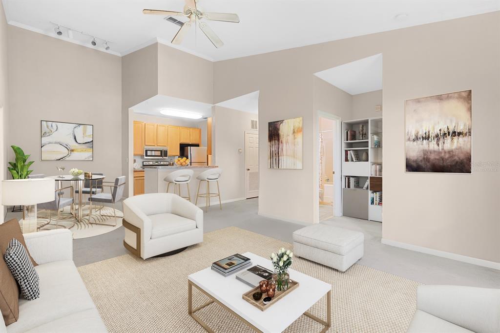This living room features high ceilings, a ceiling fan, and an open-concept kitchen area — 10211 COURTNEY PALMS UNIT 303, TAMPA, FL