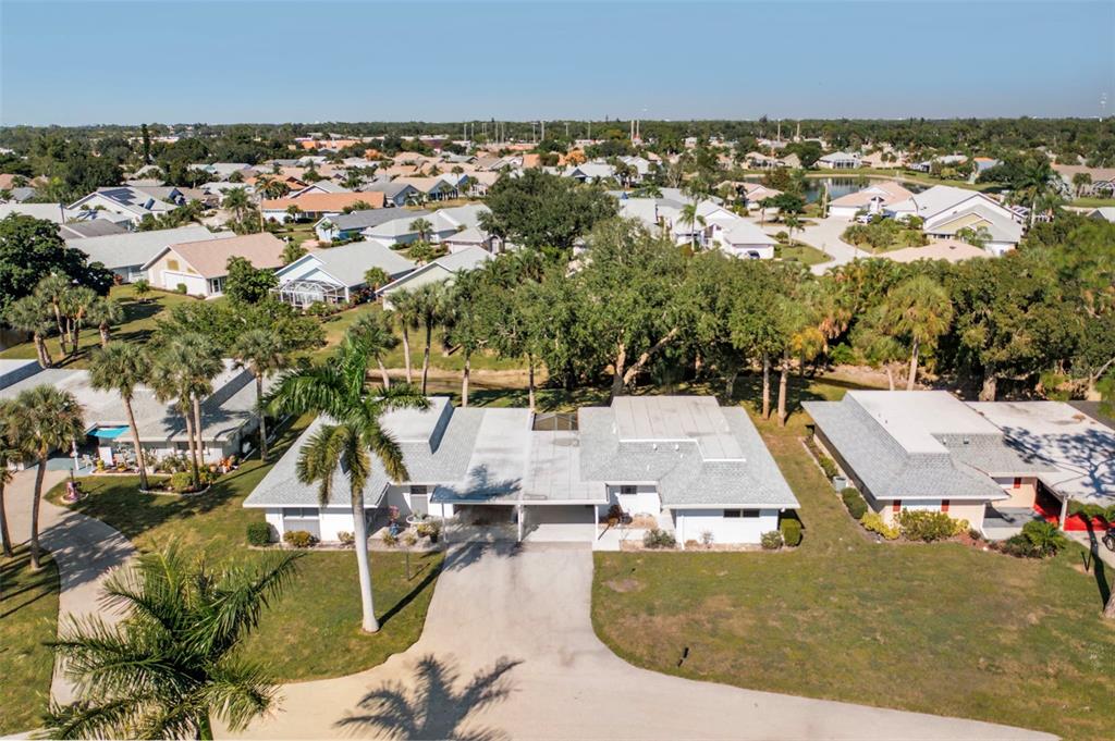 An aerial view shows a single-story house with a white exterior, gray roof, and carport — 536 PANGOLA DRIVE, NORTH FORT MYERS, FL