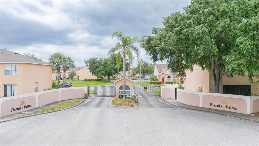 The gated entrance to the Florida Palms residential community features a security gate and signage — 649 CAPTIVA CIRCLE, KISSIMMEE, FL