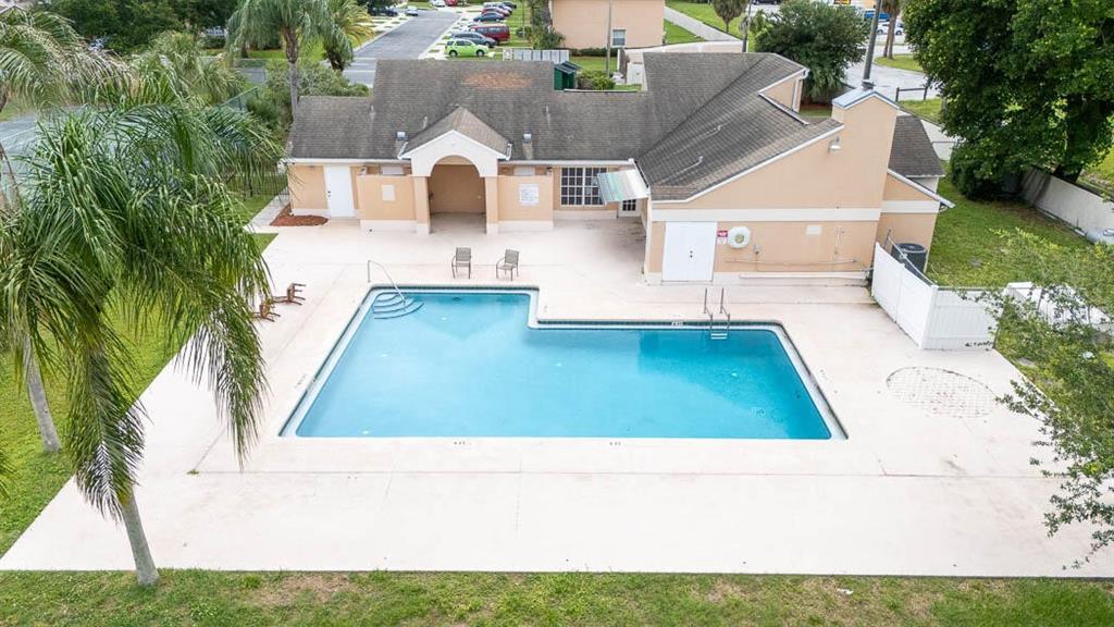 An aerial view of a community swimming pool and a beige clubhouse building — 649 CAPTIVA CIRCLE, KISSIMMEE, FL