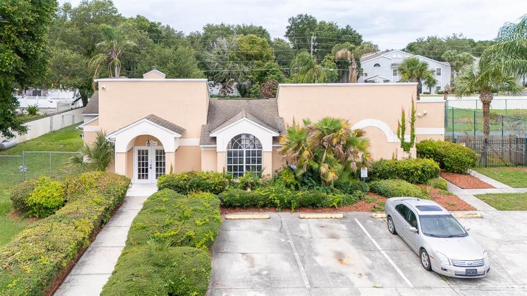 An exterior view of a tan commercial building with a parking lot and landscaping — 649 CAPTIVA CIRCLE, KISSIMMEE, FL