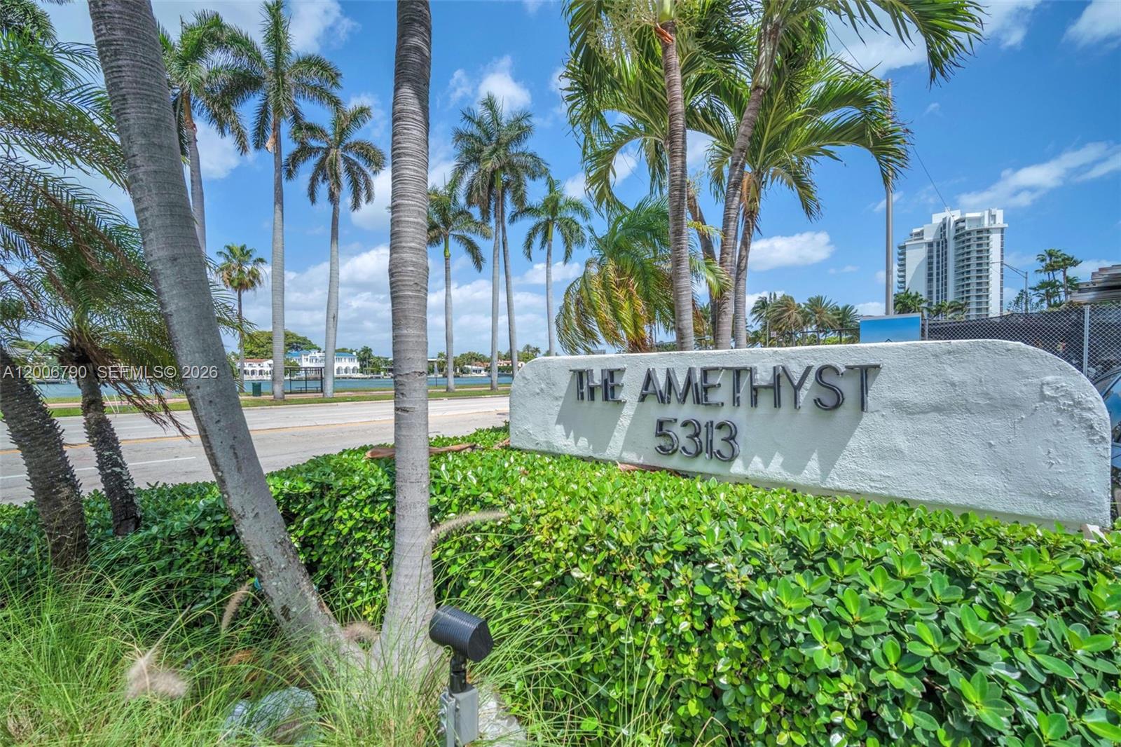 A white stone sign reading The Amethyst 5313 sits in front of palm trees and greenery — 5313 Collins Ave # 204, Miami Beach FL 33140, MIAMI BEACH, FL