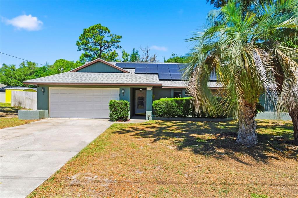 A living room features a large sectional sofa, a television, and a gallery wall — 7377 SKYLARK DRIVE, SPRING HILL, FL