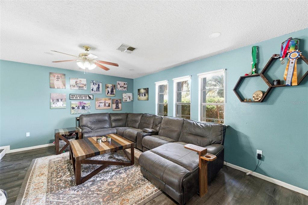 A living room features a sunken floor area, light blue walls, and a wooden play loft — 7377 SKYLARK DRIVE, SPRING HILL, FL