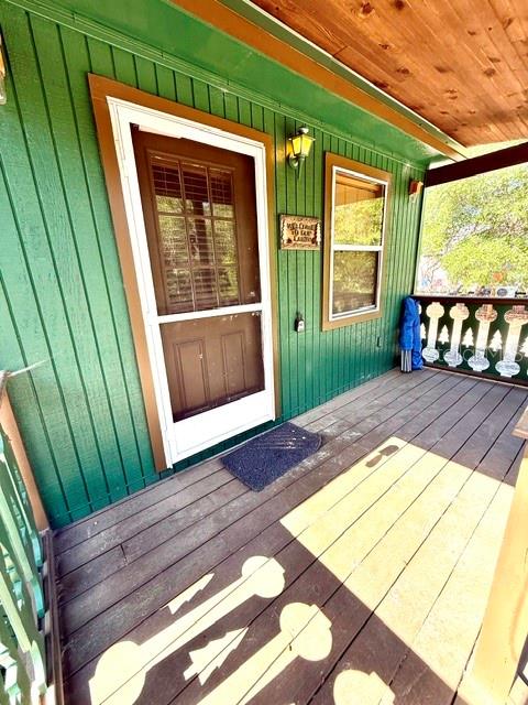 A wooden porch with green siding features a door with a screen and a window — 15920 NE 236TH LANE, FORT MC COY, FL