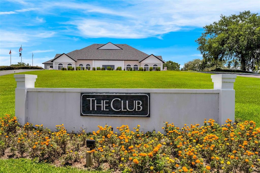 A white monument sign reading The Club sits in front of a large community building — 9322 SEVE COURT, WEEKI WACHEE, FL