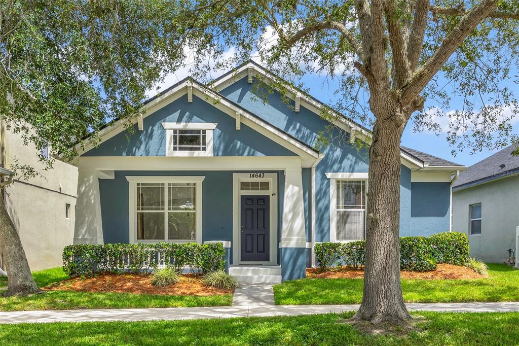 A blue single-story house with a front porch, white trim, and a small front yard — 14643 TANJA KING BOULEVARD, ORLANDO, FL