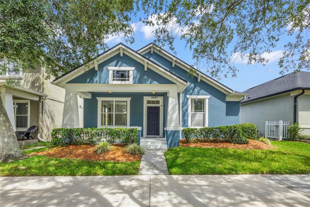 A blue single-story house features a front porch with white columns and a walkway — 14643 TANJA KING BOULEVARD, ORLANDO, FL