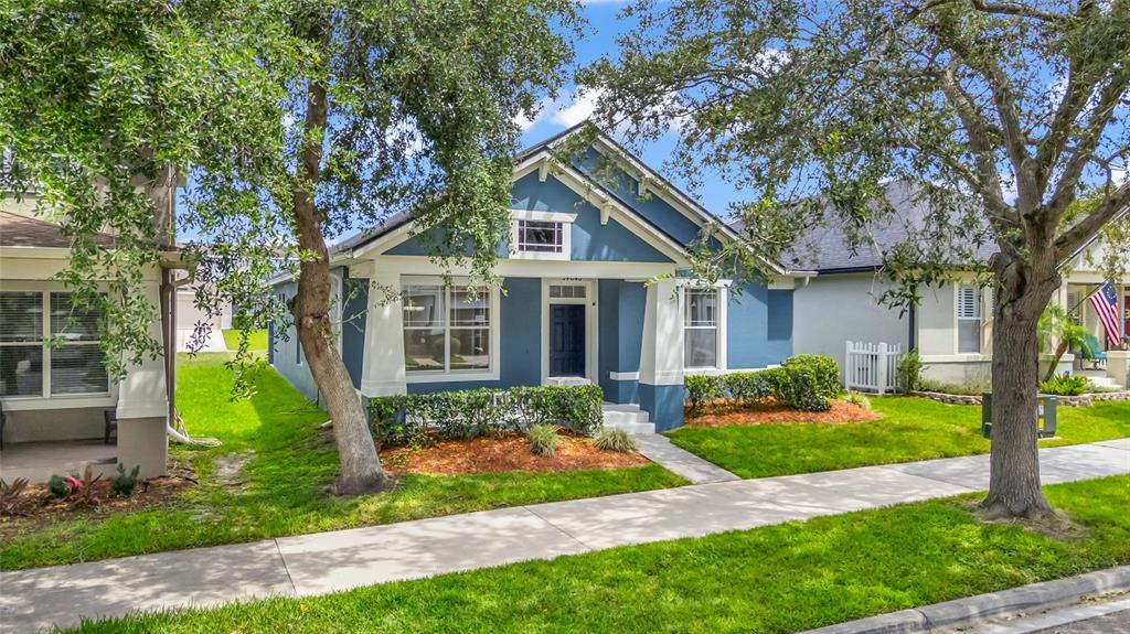A blue single-story house with a front porch and white trim sits behind a sidewalk — 14643 TANJA KING BOULEVARD, ORLANDO, FL