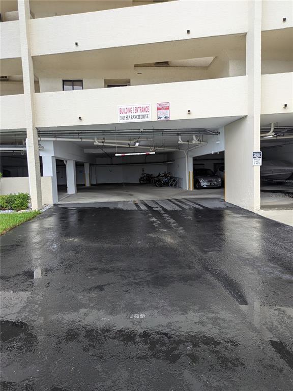 A ground-level covered parking area beneath a multi-story residential building — 5915 SEA RANCH DRIVE UNIT 404, HUDSON, FL
