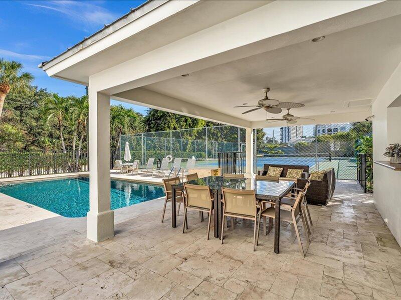 A covered patio features a dining set, ceiling fans, and a view of a pool — 277 N Ocean Boulevard # 304, Boca Raton FL 33432, BOCA RATON, FL