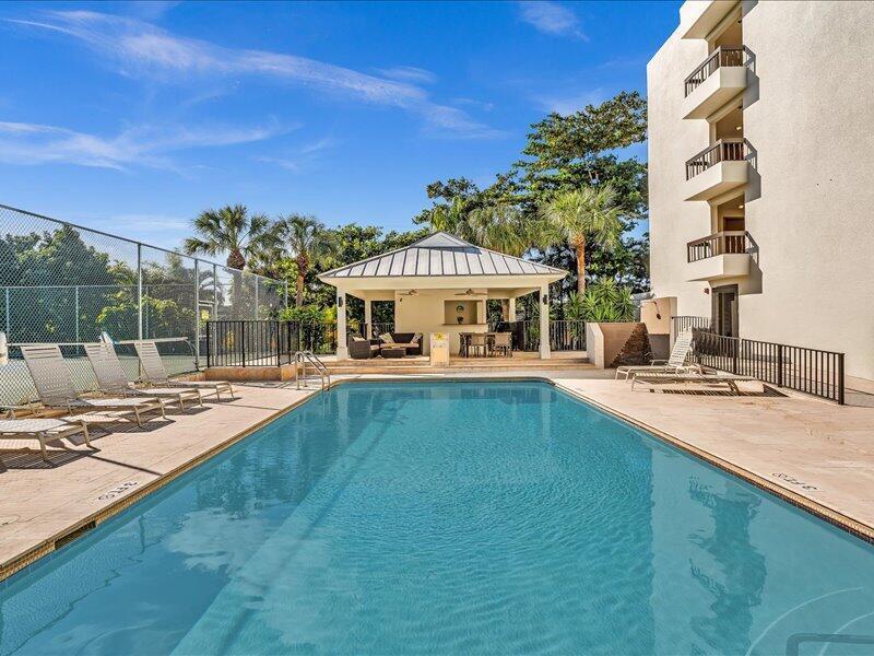 A rectangular swimming pool sits beside a multi-story building and a covered outdoor pavilion — 277 N Ocean Boulevard # 304, Boca Raton FL 33432, BOCA RATON, FL