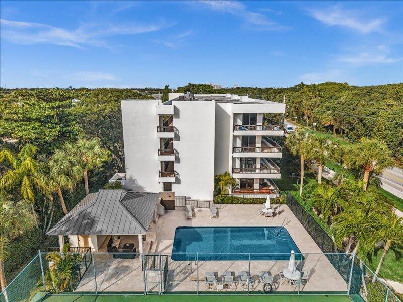 An aerial view shows a multi-story apartment building with a swimming pool and patio area — 277 N Ocean Boulevard # 304, Boca Raton FL 33432, BOCA RATON, FL