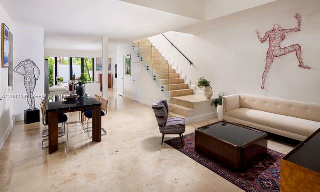 A modern living and dining area features a glass-railed staircase and light stone flooring — 2766 SW 33rd Ave # 2766, Miami FL 33133, MIAMI, FL