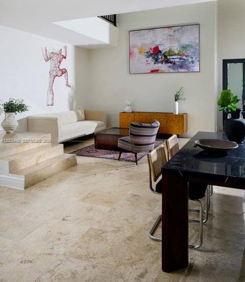 A modern living and dining area features travertine floors, a white sofa, and abstract wall art — 2766 SW 33rd Ave # 2766, Miami FL 33133, MIAMI, FL