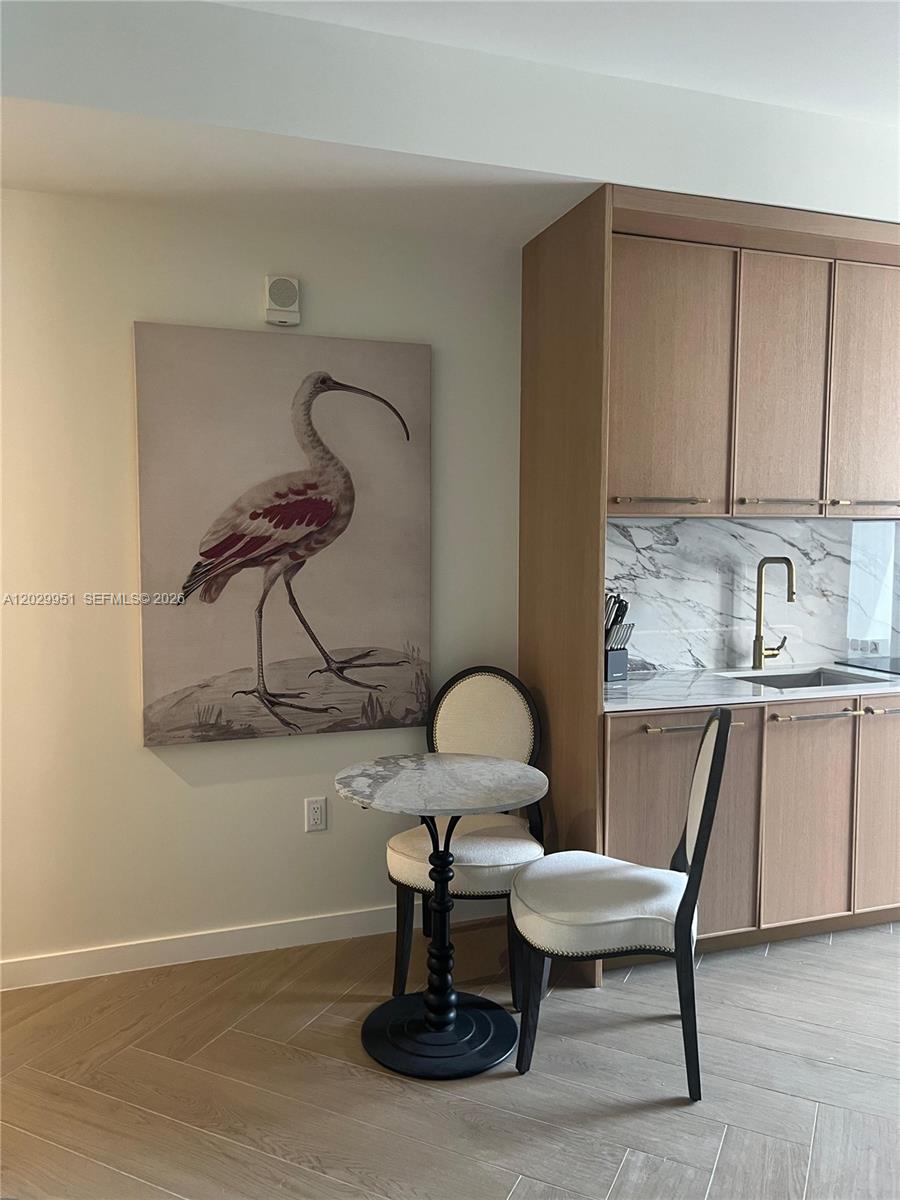 A small dining area features a marble bistro table, two chairs, and a bird painting — 2700 NW 2nd Ave # 544, Miami FL 33127, MIAMI, FL