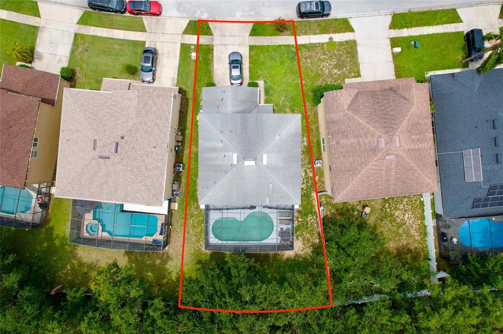 An aerial view shows a house with a pool and screened lanai on a lot — 16816 RISING STAR DRIVE, CLERMONT, FL