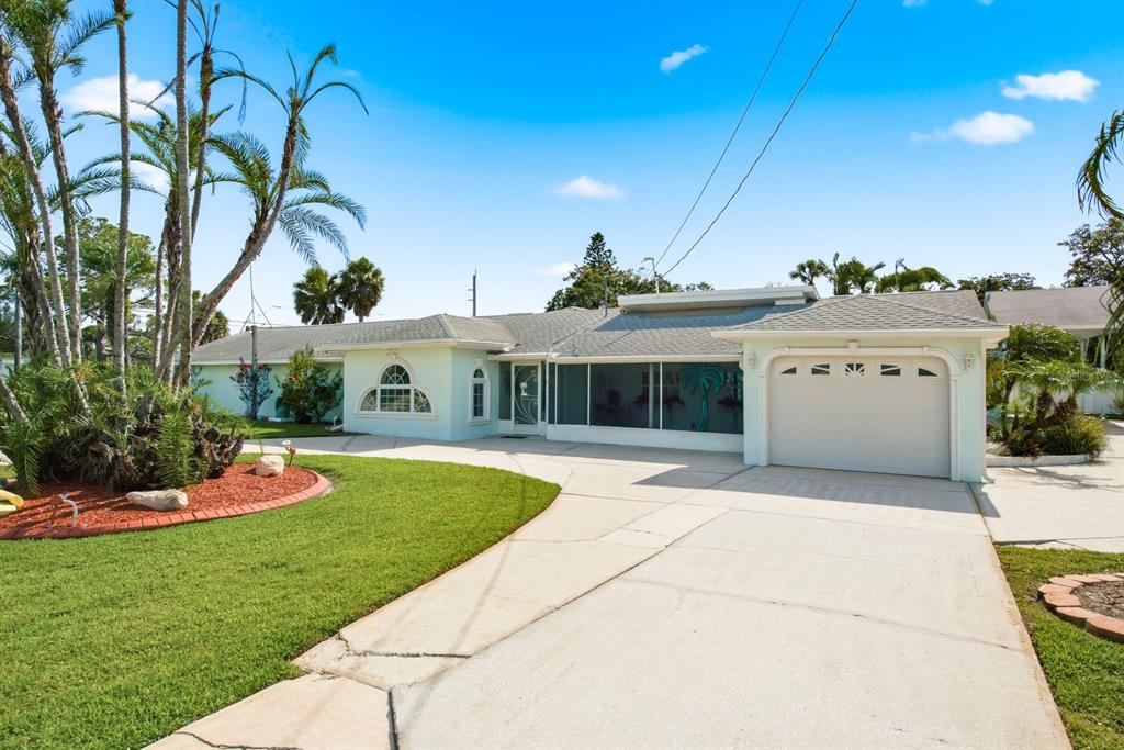 A light green single-story house with a screened porch, attached garage, and palm trees — 6309 WERNER AVENUE, NEW PORT RICHEY, FL