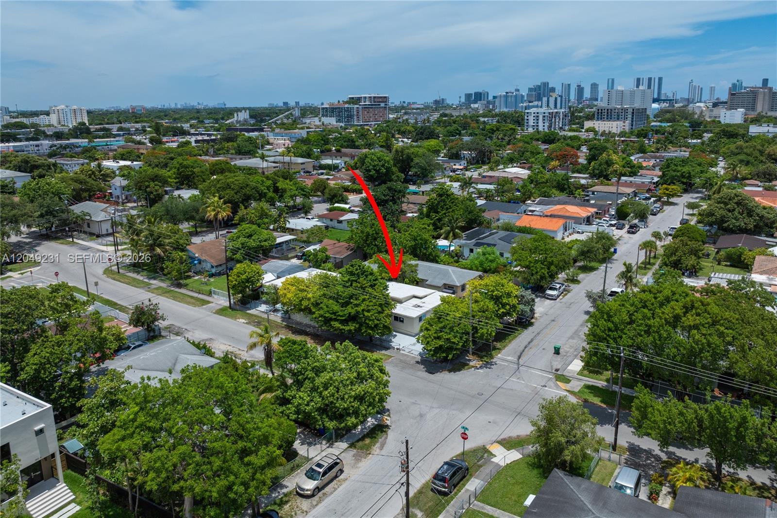 An aerial view shows a single-story house with a flat roof surrounded by lush trees — 1701 NW 19th Ave # 1701, Miami FL 33125, MIAMI, FL