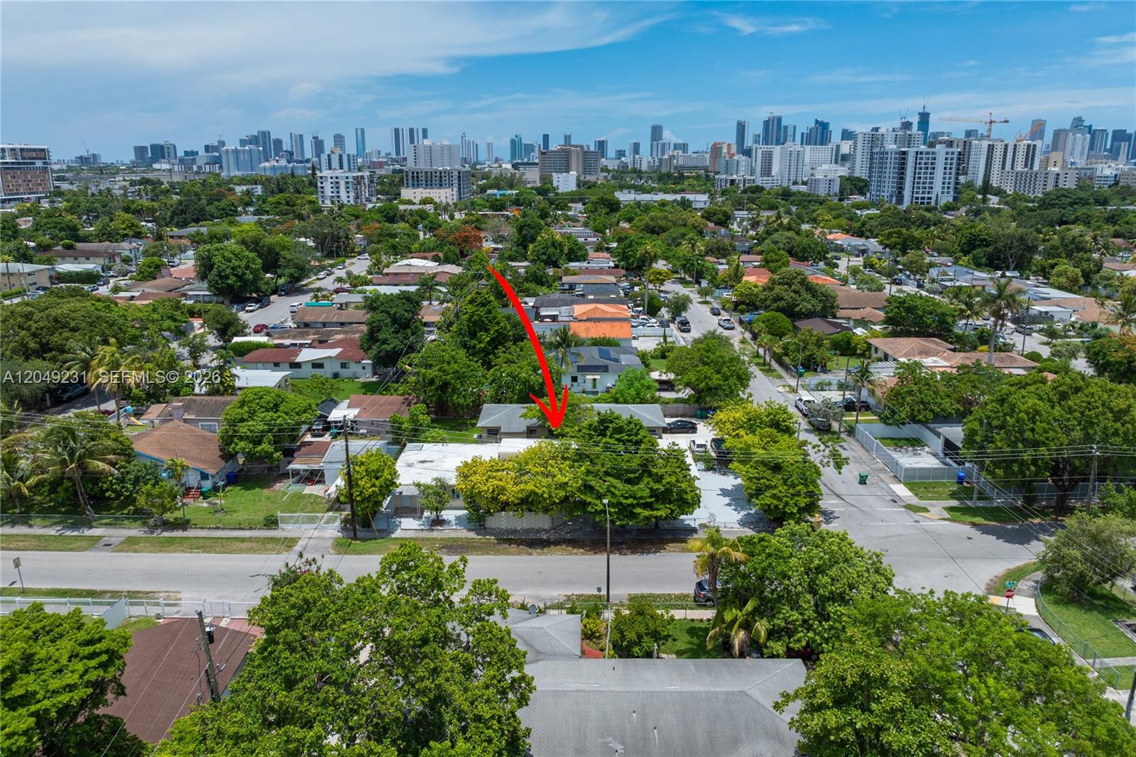 An aerial view shows a single-story house with a flat roof and surrounding trees — 1701 NW 19th Ave # 1701, Miami FL 33125, MIAMI, FL