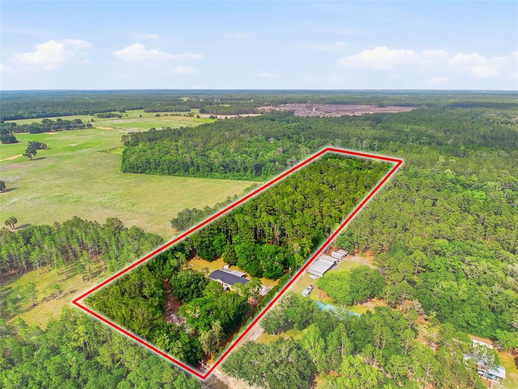 An aerial view shows a house and outbuildings on a wooded lot outlined in red — 17926 SE 49TH PLACE, HAWTHORNE, FL