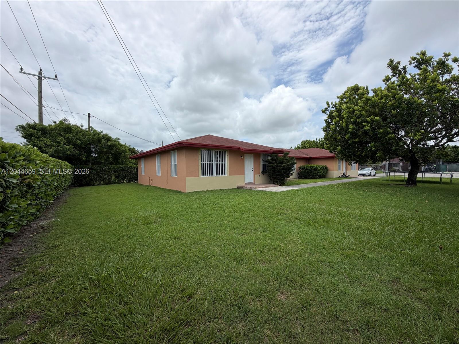 A single-story house with peach-colored walls and a red roof sits on a grassy lot — 10530 SW 183rd St # 2, Miami FL 33157, MIAMI, FL