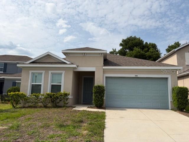 A single-story house with a beige exterior, a two-car garage, and a front entrance — 998 GRAND HILLTOP, APOPKA, FL