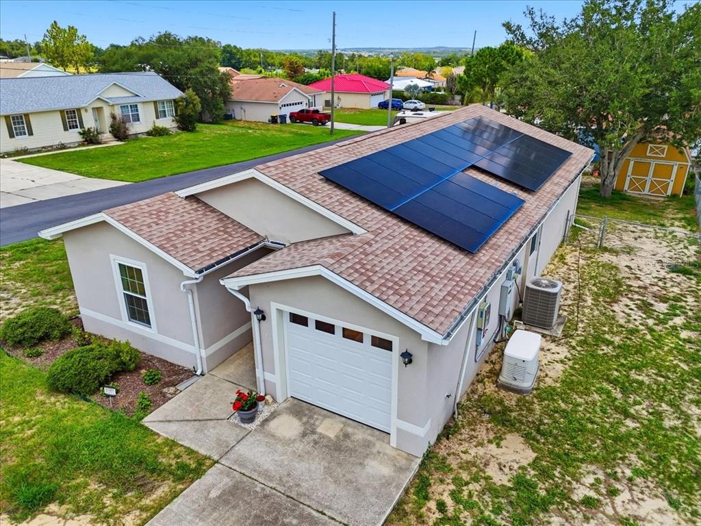 An aerial view of a single-story house with a solar panel array on the roof — 115 SEMINOLE ROAD, BABSON PARK, FL