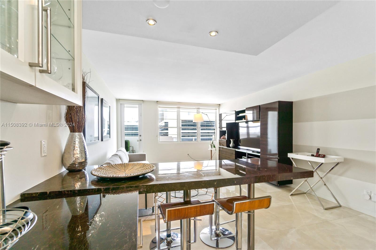 A modern living room features a dark marble breakfast bar, stools, and a media console — 100 Lincoln Rd # 1202, Miami Beach FL 33139, MIAMI BEACH, FL