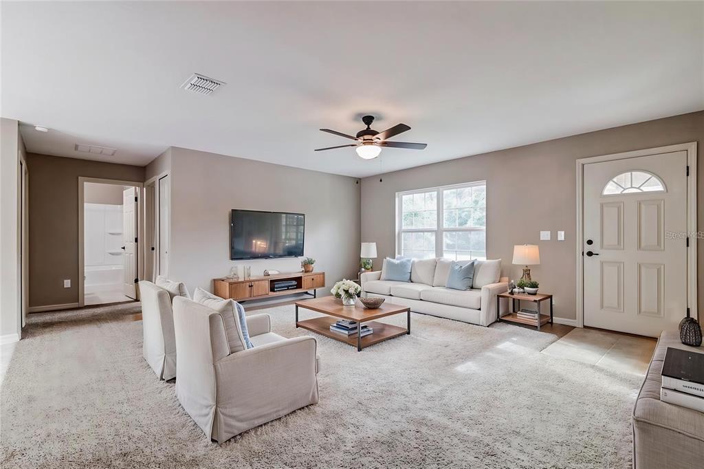 A living room features beige walls, a white sofa, two armchairs, and a ceiling fan — 3468 SW 165TH LOOP, OCALA, FL