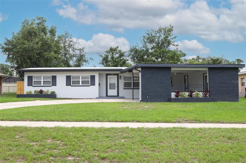 A single-story house with a white and dark gray brick exterior and a front porch — 4422 GILPIN WAY, ORLANDO, FL