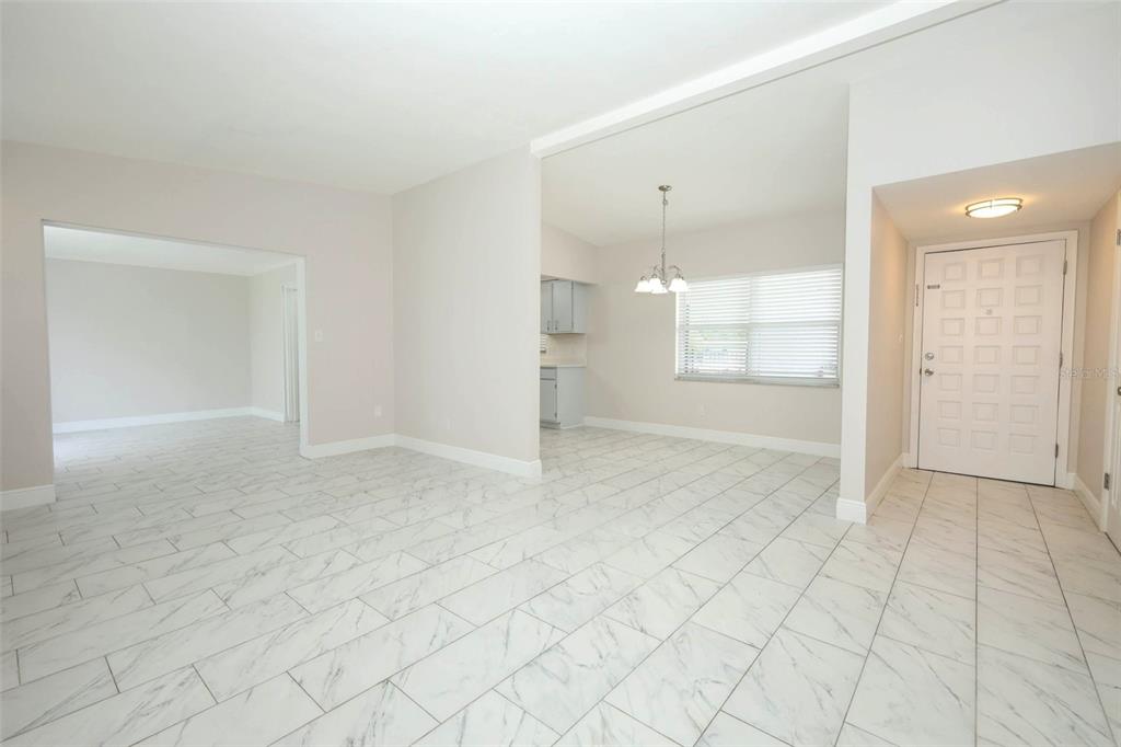 An interior view shows a tiled living area leading to a dining space and entryway — 4422 GILPIN WAY, ORLANDO, FL