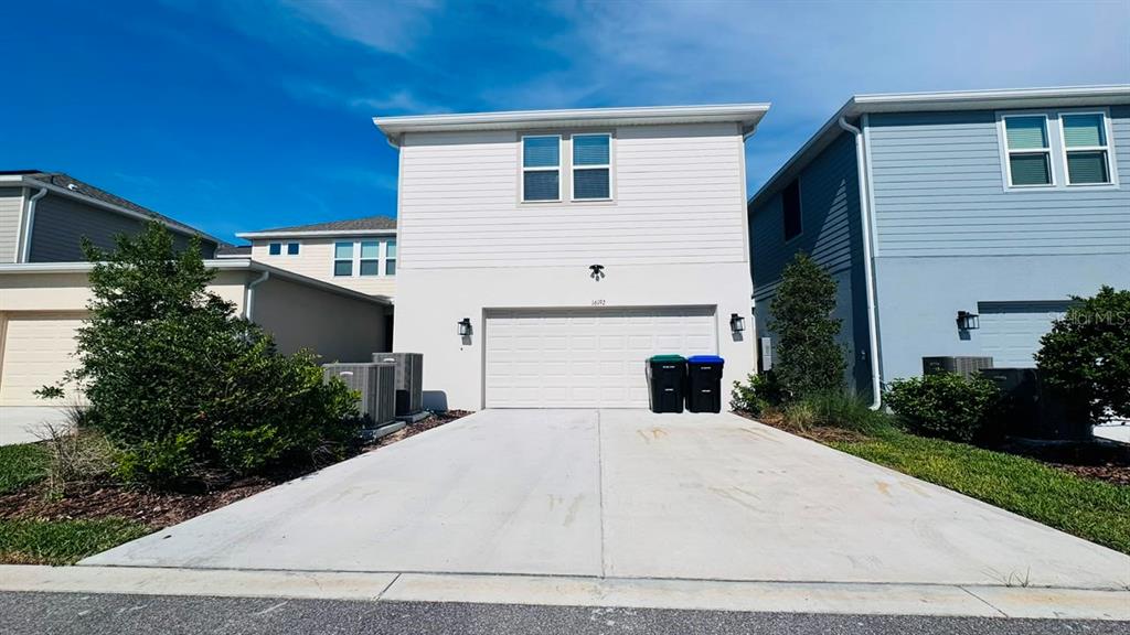 A two-story house with a white exterior, a two-car garage, and a concrete driveway — 16192 HONEY HARVEST STREET, WINTER GARDEN, FL