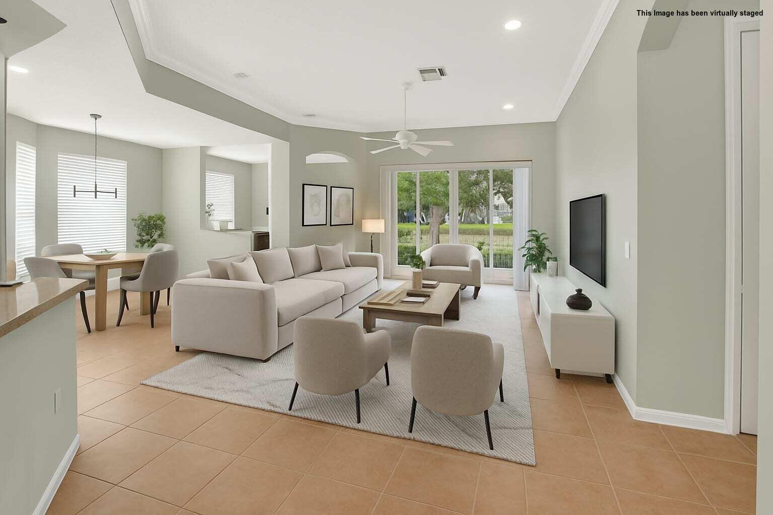 This virtually staged living room features tile flooring, a neutral sofa, and sliding glass doors — 6604 Southport Drive, Boynton Beach FL 33472, BOYNTON BEACH, FL