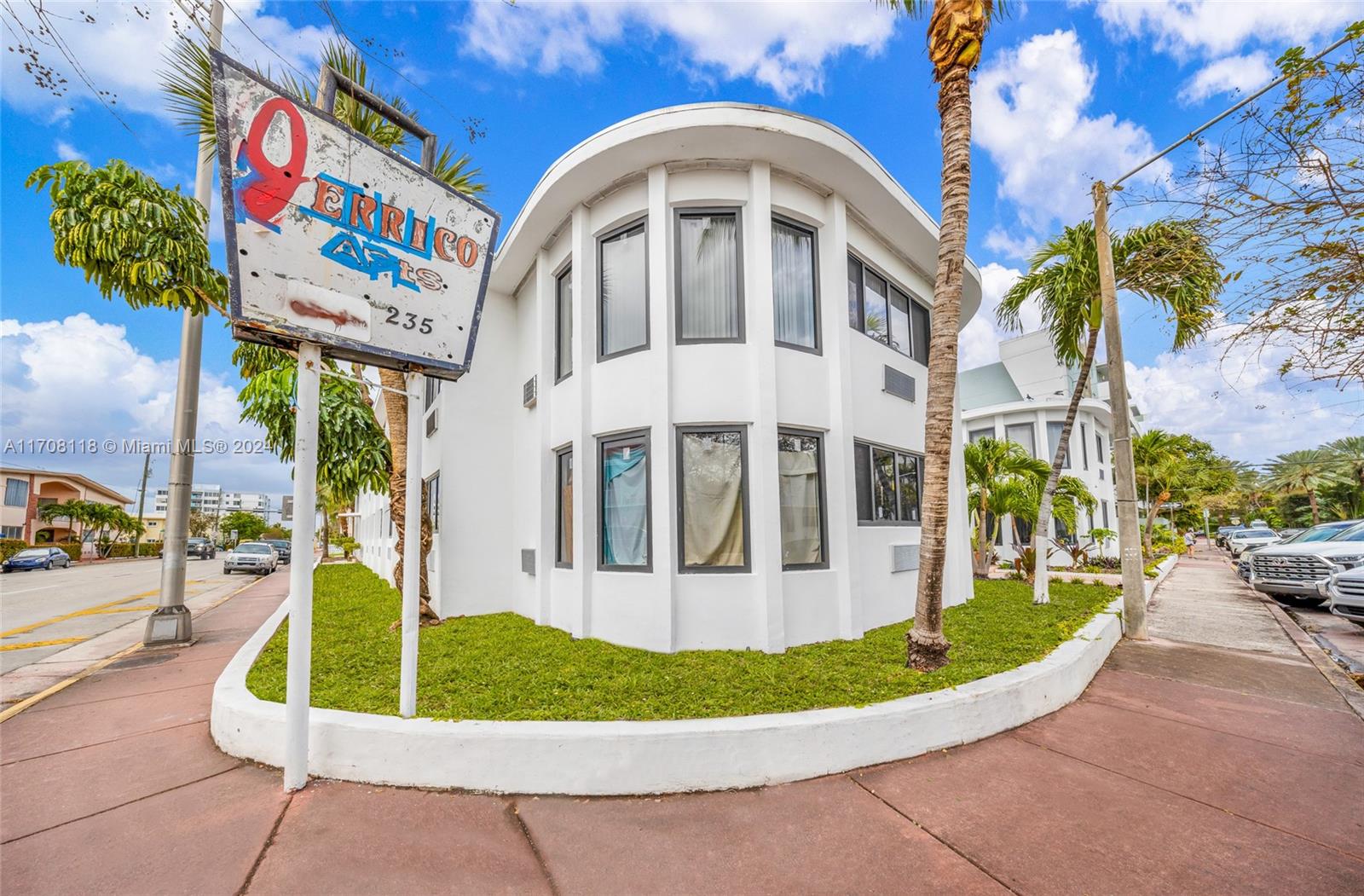 A white, curved apartment building stands on a corner lot with a prominent street sign — 235 78th St, Miami Beach FL 33141, MIAMI BEACH, FL
