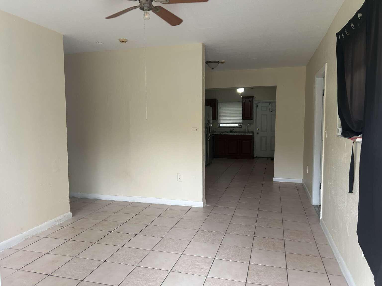 A view from a tiled living area looking toward a kitchen with dark wood cabinets — 3370 NW 8th Place, Lauderhill FL 33311, LAUDERHILL, FL